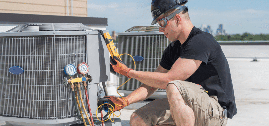 HVAC technician testing and maintaining commercial rooftop AC units in Mercedes, Texas.